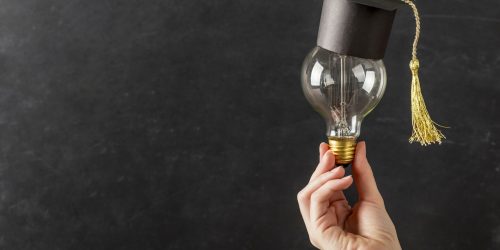 person-holding-light-bulb-with-graduation-cap